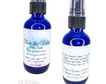 May include: Two blue glass bottles with spray tops, labelled "Clear the Vibes Palo Santo" and "Full Moon Charged Water". The bottles contain a blend of essential oils and crystals for energy clearing and cleansing. The bottles are labelled with the text "Maria Voorhees Reincke Intuitive Energy Healer (651) 380-8465".