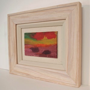 May include: A framed abstract painting with a red, orange, yellow, green, and purple colour scheme. The painting is signed "C. Caputi" in the bottom right corner.