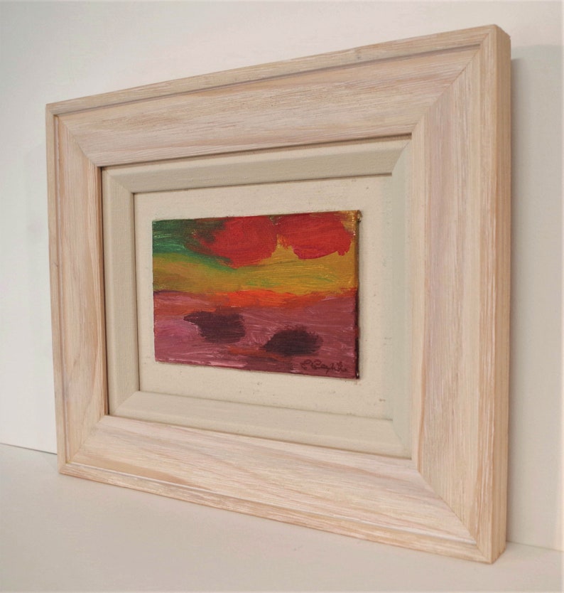 May include: A framed abstract painting with a red, orange, yellow, green, and purple colour scheme. The painting is signed "C. Caputi" in the bottom right corner.