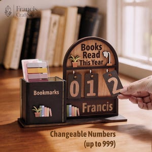 May include: A wooden desk organizer with a bookmark holder and a "Books Read This Year" counter. The counter displays "012" with changeable numbers up to 999. The organizer has the name "Francis" on it.