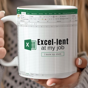 以下が含まれることがあります： 緑色のエクセルのロゴと「Excel-lent at my job I know my sheet」というテキストが書かれた白いコーヒーカップ。カップはスプレッドシートの背景になっています。
