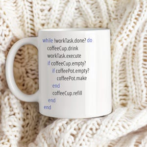 Op de afbeelding: Een witte keramische mok met zwarte tekst die luidt: "while !workTask.done? do coffeeCup.drink workTask.execute if coffeeCup.empty? if coffeePot.empty? coffeePot.make end coffeeCup.refill end end"