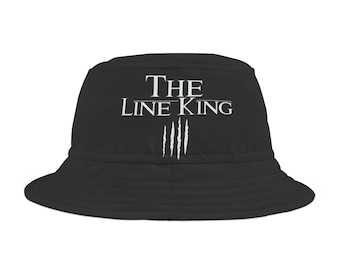 May include: Black bucket hat with white text that reads "THE LINE KING" and four white claw marks below the text.