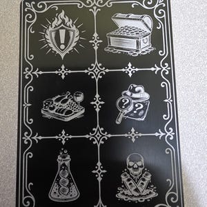 May include: Black rectangular game board with silver-colored illustrations. The board features a shield with flames, a treasure chest, a plate of food with a wine glass, a detective with a magnifying glass, a flask with DNA, and a skull with poison bottles.