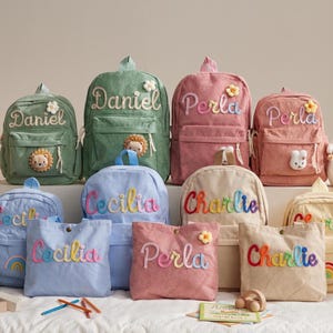 May include: A collection of corduroy backpacks and tote bags in various colors, personalized with names like "Daniel," "Perla," and "Charlie." Each bag features decorative accents such as flowers and animal appliqués. The bags are designed for children.