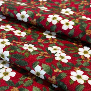 Julblommigt bomullstyg med järnek - Röd julgrönsak och vitt blommönster