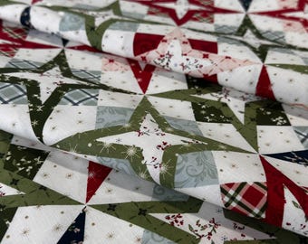 May include: A folded piece of fabric featuring a repeating star pattern in shades of red, dark green, and white. The design includes various textures such as plaid, floral, and snowflake motifs within the star shapes and background squares.