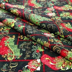 以下が含まれることがあります： 黒色の生地に、クリスマスをテーマにした繰り返し模様。赤い靴下、緑色のヒイラギ、金のベル、そして「サンタクロース」と「そりベルが鳴る」というテキストが含まれています。生地は折りたたまれ、パターンの繰り返しを示しています。