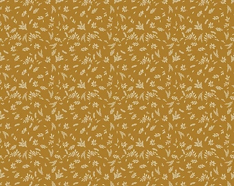 May include: A mustard yellow fabric featuring a repeating pattern of small, white, delicate leaf sprigs. A white ruler at the bottom edge indicates a scale of 12 inches, with the text Riley Blake Designs printed clearly on the left side.
