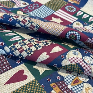 May include: Close-up of a patchwork fabric with a variety of patterns and colors. The design includes hearts, stars, and checkered squares in shades of red, blue, green, and beige. The fabric is likely used for quilting or crafting.