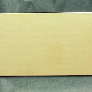 May include: A plain, rectangular, light beige plaque with a smooth surface.