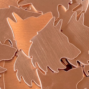 May include: A pile of copper-colored metal cutouts in the shape of a dog's head.
