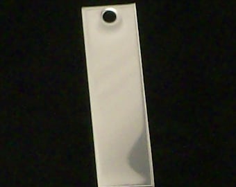 May include: A silver rectangular tag with a round hole in the top.