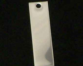 May include: A silver rectangular tag with a round hole in the top.