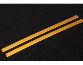 May include: Two thin, flat strips of gold-colored metal.
