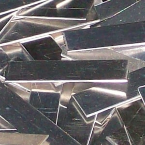 May include: A pile of silver-coloured metal strips, likely scrap metal, with a reflective surface.