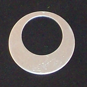 May include: A silver metal washer with a large hole in the centre.
