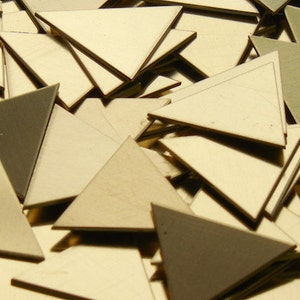 May include: A pile of small, triangular pieces of wood in various shades of beige and gray. The pieces are arranged in a random pattern, with some overlapping.