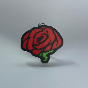 Könnte beinhalten: Eine rote Rose mit einem grünen Stiel, schwarz umrandet, ist auf weißem Hintergrund abgebildet. Die Rose ist ein schlichtes, stilisiertes Design.