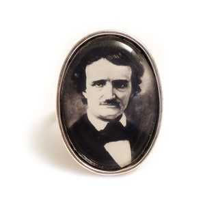 Op de afbeelding: Een zilveren ring met een zwart-witfoto van Edgar Allan Poe in een cameo.