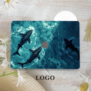May include: A laptop case featuring a design of sharks swimming in a turquoise ocean. The case has a stylized Apple logo and the word "LOGO" at the bottom. The sharks are dark gray, and the water has a textured appearance.