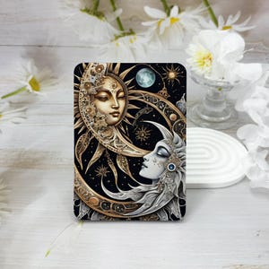 May include: A black background with a gold and silver sun and moon design. The sun and moon are stylized with faces and are surrounded by gears and stars.