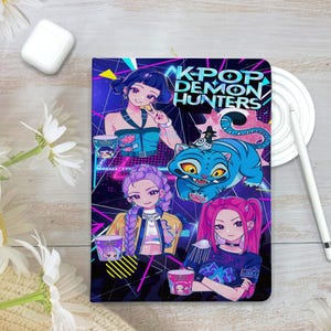May include: A notebook featuring a vibrant illustration with the text "K-POP DEMON HUNTERS." The design includes anime-style characters, a blue tiger, and neon accents. The notebook is rectangular and has a glossy finish.
