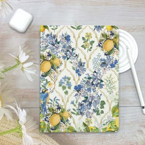 May include: A white background with a gold and blue floral pattern. The pattern includes lemons, birds, and flowers. The design is repeated throughout the background.