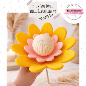 Puede incluir: Una decoración floral en capas con pétalos amarillos, pétalos internos rosas y un centro color crema. La flor se sostiene con un palito de madera. El texto en la imagen dice "STL + 3MF DATEI INKL. GEWERBELIZENZ" y un logotipo.