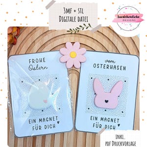 Könnte beinhalten: Zwei Ostermagnete mit dem Text "Frohe Ostern" und "Ein Magnet Für Dich". Ein Magnet zeigt eine weiße Eiform, der andere ein rosa Häschen. Eine rosa Blume verziert die Oberseite. Der Text "3MF + STL DIGITALE DATEI" ist ebenfalls enthalten.