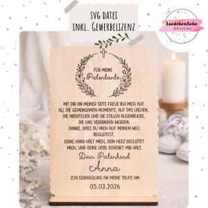 May include: A wooden baptism keepsake with a scalloped edge. The text includes "FÜR MEINE Patentante" and a dedication to a godparent, with the date 05.03.2026. A cross and floral wreath design is featured.