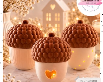 May include: Three acorn-shaped containers with textured brown caps and smooth white bases. The central container features a heart-shaped cutout, while the right container has small circular cutouts. The text Laedchenliebe DESIGNS and STL + 3MF Datei INKL. GEWERBELIZENZ is visible.