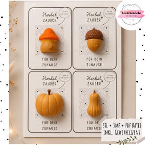 Könnte beinhalten: Ein Set aus vier dekorativen Magneten in herbstlichen Formen: ein orangefarbener Pilz, eine braune Eichel, ein runder Kürbis und ein Flaschenkürbis. Jeder ist auf einer Karte mit den Texten Herbst Zauber, Für Dein Zuhause und Ich bin ein Magnet befestigt.