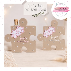 May include: Two beige puzzle piece decorations with white heart accents and the words "just married" in pink script. One piece has a corked bottle. The puzzle pieces also have "Mr & Mrs" on them.