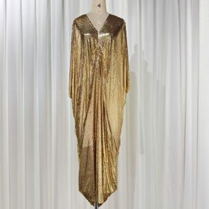 gold chainmail dress versace Lupita Nyong'o wearing a gold chainmail #AtelierVersace gown with one shoulder neckline accented by a bold statement shoulder silhouette encrusted with Swarovski crystal accents at the 90th Annual Academy Awards. #Oscars90 Versace.com
