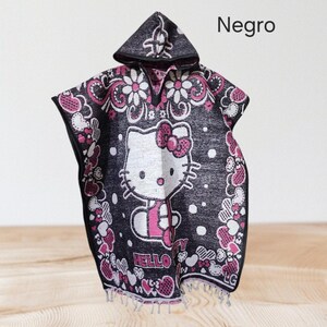 May include: Black hooded poncho with a Hello Kitty design in white and pink. The poncho is decorated with pink and white floral and heart patterns. The word "Hello" is visible on the front. The word "Negro" is written on the top right.