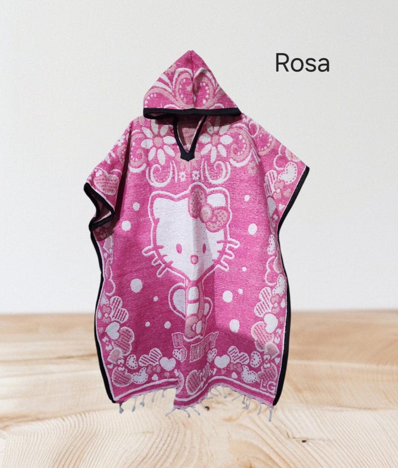 May include: Pink hooded poncho with a Hello Kitty design. The poncho has a white floral pattern and a black trim. The word "Rosa" is printed on the top right corner.