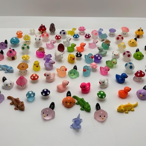 May include: A collection of colorful miniature figurines, including animals, plants, and mushrooms. The figurines are made of plastic and are about 1 inch tall.
