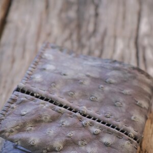 cuero de avestruz. cosido a mano. borde crudo. Detalle de cremallera plateada. billetera