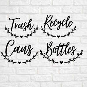 May include: Four black and white signs with a leafy wreath design and a heart. The signs read "Trash Cans", "Recycle Bottles", "Trash", and "Recycle".
