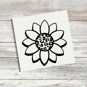 May include: A square white decal featuring a black outline of a sunflower. The center of the flower is filled with a black and white leopard print pattern. The design is centered on the white background with clean, bold lines defining the petals.