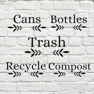 May include: White brick wall with black text labels for "Cans", "Bottles", "Trash", "Recycle", and "Compost". Each label is centered and has decorative leaf accents.