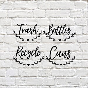 May include: Four black labels with white brick background. The labels read "Trash", "Bottles", "Recycle", and "Cans" in a decorative script font. Each word is encircled by a leafy wreath with a small heart at the bottom.