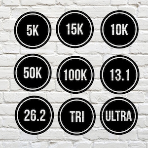 May include: Nine black and white circular stickers with different running distances and a triathlon symbol. The stickers include 5K, 10K, 15K, 50K, 100K, 13.1, 26.2, TRI, and ULTRA.