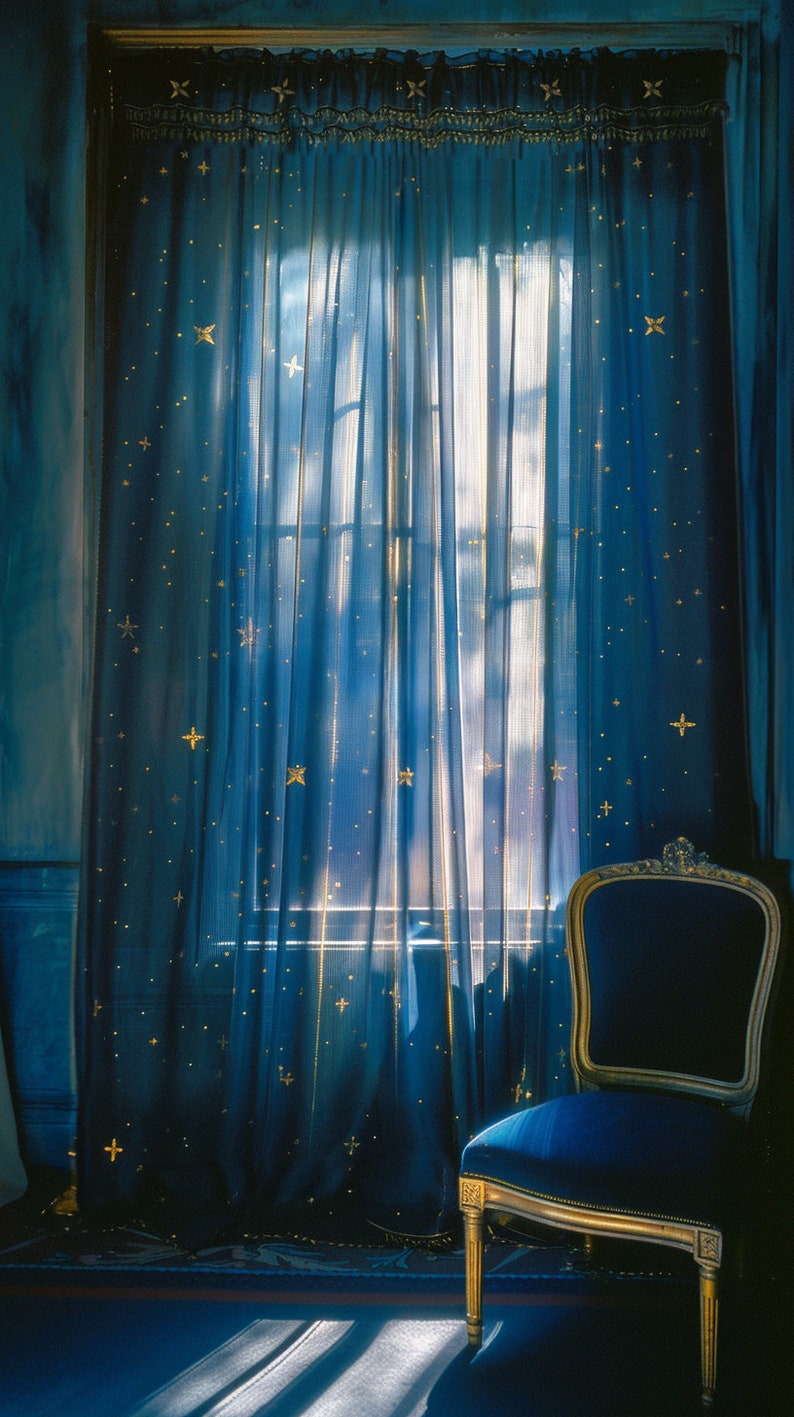 Pode incluir: Uma cadeira de veludo azul com moldura dourada fica em frente a uma janela com cortinas azuis adornadas com estrelas douradas. As cortinas s&atilde;o transparentes e permitem que a luz brilhe.