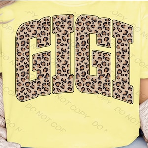 May include: A yellow t-shirt with the word "GIGI" printed in a brown leopard print.