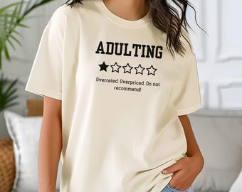 May include: Ivory t-shirt with the text "Adulting" and a 1-star rating. The text below the rating says "Overrated. Overpriced. Do not recommend!"