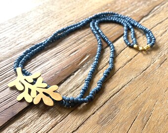 Handmade blue seed bead necklace with gold-plated leafy charm - Nature-inspired jewelry for everyday elegance