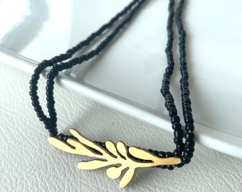 Handmade black seed bead necklace with gold-plated leafy charm - Nature-inspired jewelry for everyday elegance