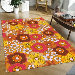 Puede incluir: Una alfombra colorida con un patrón floral retro. La alfombra presenta una variedad de flores en tonos naranja, amarillo, rosa y marrón sobre un fondo naranja claro.